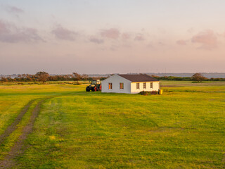 Pasture with barn and tractor on Langeoog island, East Frisia, Lower Saxony, Germany