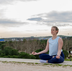 Naklejka na ściany i meble Young fit woman practice meditation outdoors