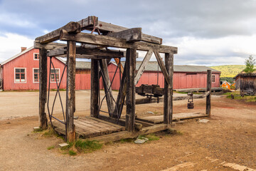 Fototapeta na wymiar The remnants of an old mine elevator stand as a historical monument in Roros, surrounded by the town's distinctive wooden buildings and mining heritage. Norway