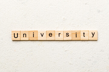 UNIVERSITY word written on wood block. UNIVERSITY text on cement table for your desing, concept