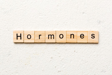 hormones word written on wood block. hormones text on table, concept