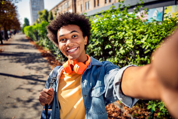 Photo of funky funny guy wear denim jacket earphones recording video vlog outside urban city street