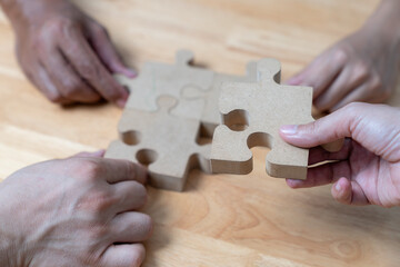The hands that are helping each other assemble the jigsaw puzzle, Business connection concept