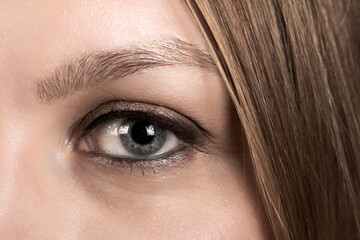 Close-up of gray female eye with beautifully detailed pupil and eyelashes