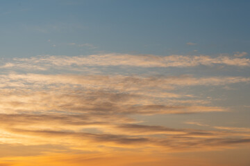 Photo background texture of orange sky at sunset with clouds.