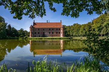 Fototapeta na wymiar 05-09-2023 Hornslet, Denmark: Rosenholm castle, with lake in foreground, blue sky summer