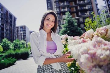 Fotobehang Photo of pretty cute cheerful girl dressed trendy clothes walking in botany garden blooming flowers spring time outdoors © deagreez