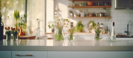 A kitchen counter is adorned with several vases filled with colorful flowers, adding a touch of freshness and beauty to the space. The vases vary in size and shape,
