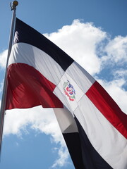 Flag of Dominican Republic waving in the wind, sky background. 