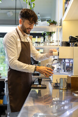 Man barista brewing coffee in cafe expertly handles the portafilter grinding coffee beans