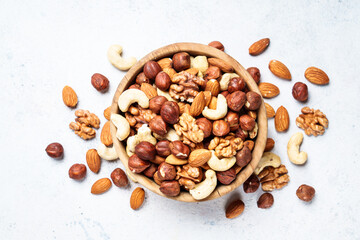 Nuts assortment at white background. Almond, hazelnut, cashew in wooden bowl.