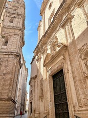 facades of old historic buildings, sandstone buildings, high church, church tower, tourist between buildings, Italian landmarks