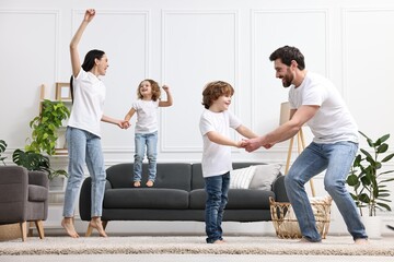 Fototapeta premium Happy family dancing and having fun in living room