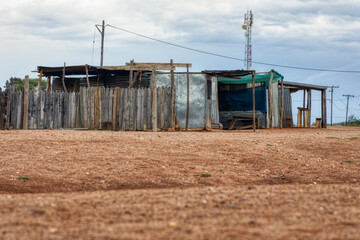 township informal settlement in africa near a hill, shack made out of corrugated iron and wood, modern facilities electricity and cellular network - obrazy, fototapety, plakaty