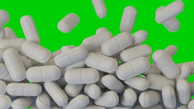 white pills fall and cover the green screen