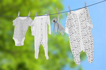 Baby clothes and crochet toy drying on washing line outdoors