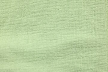 Texture of light green fabric as background, top view