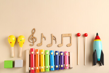 Baby song concept. Wooden notes, kids xylophone and toys on beige background, flat lay. Space for...