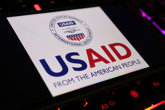 Viersen, Germany - January 9. 2024: Smartphone screen with logo lettering of USAID government agency on computer keyboard