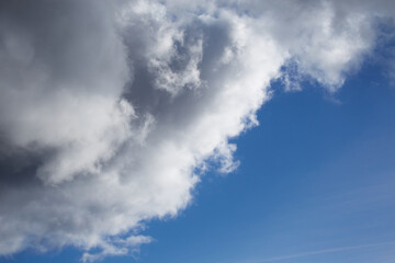 A large cumulus cloud covers the blue sky, a large cloud covers the blue sky