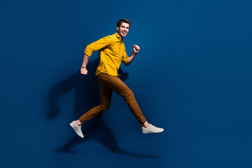 Fototapeta na wymiar Full length photo of nice young male jumping run black friday promo wear trendy yellow garment isolated on dark blue color background