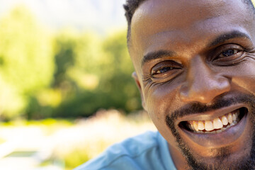 African American man smiles broadly, showcasing a warm expression at home with copy space