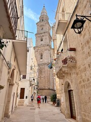 facades of old historic buildings, sandstone buildings, high church, church tower, tourists between buildings, Italian landmarks