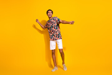 Fototapeta na wymiar Full body length size photo of funky young man in t shirt with white shorts discotheque summertime isolated on yellow color background