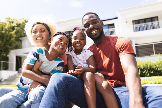 African American family with a father, mother, son, and daughter smiling outdoors