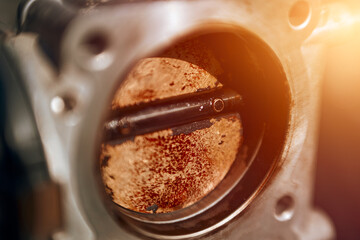 The effects of carbon on a throttle valve of a car engine. The valve blade is covered with dirt and...