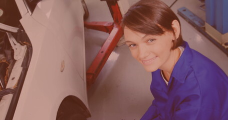 Caucasian female mechanic screwing wheel of a car by pneumatic wrench at repair service station - Powered by Adobe