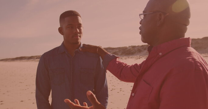 African american man talking to his son at the beach - Powered by Adobe