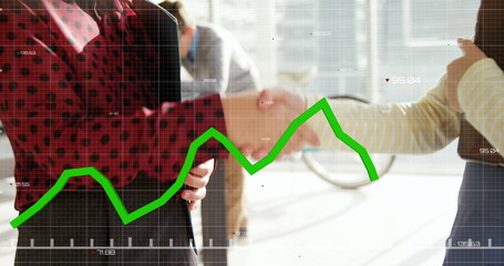 Image of financial data processing over schoolgirls working in an office together, shaking hands