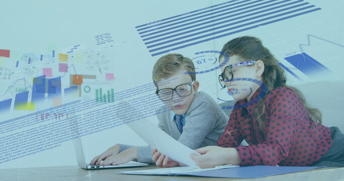 Image of financial data processing over schoolboy and schoolgirl working in an office together, usin