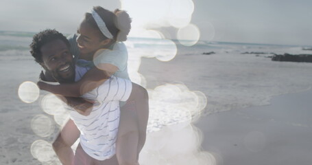 Image of happy african american couple having fun on beach over seascape