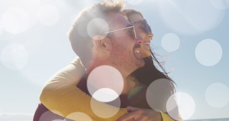 Image of dots over happy caucasian couple having fun on beach