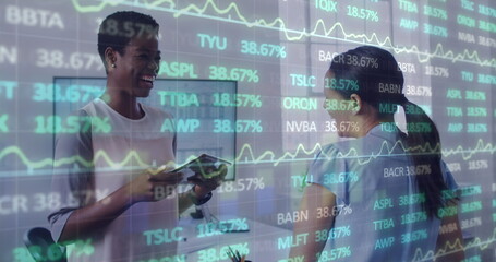 Image of financial data and graphs over diverse female coworkers in office