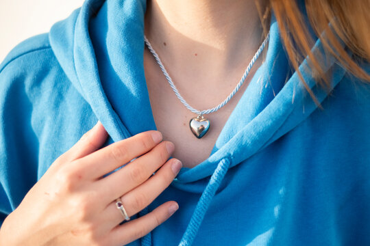 Mujer ense&ntilde;ando su collar en forma de coraz&oacute;n