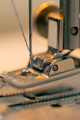 close-up in a sewing workshop thread is inserted into a needle on a machine