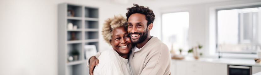 Joyful African American Mother and Son Embracing in Modern Kitchen - obrazy, fototapety, plakaty