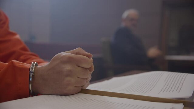 Unhappy inmate banging table in trial before lawyer and judge