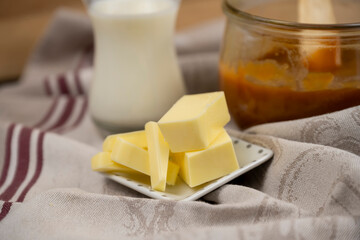 beurre salé en morceaux dans une petite coupelle, ingrédient pour une recette de caramel au...