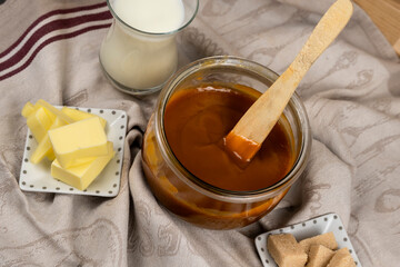 caramel au beurre salé dans un pot en verre avec les ingrédients dans la cuisine