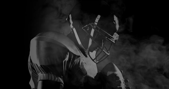 Image of male american football player over smoke on black background