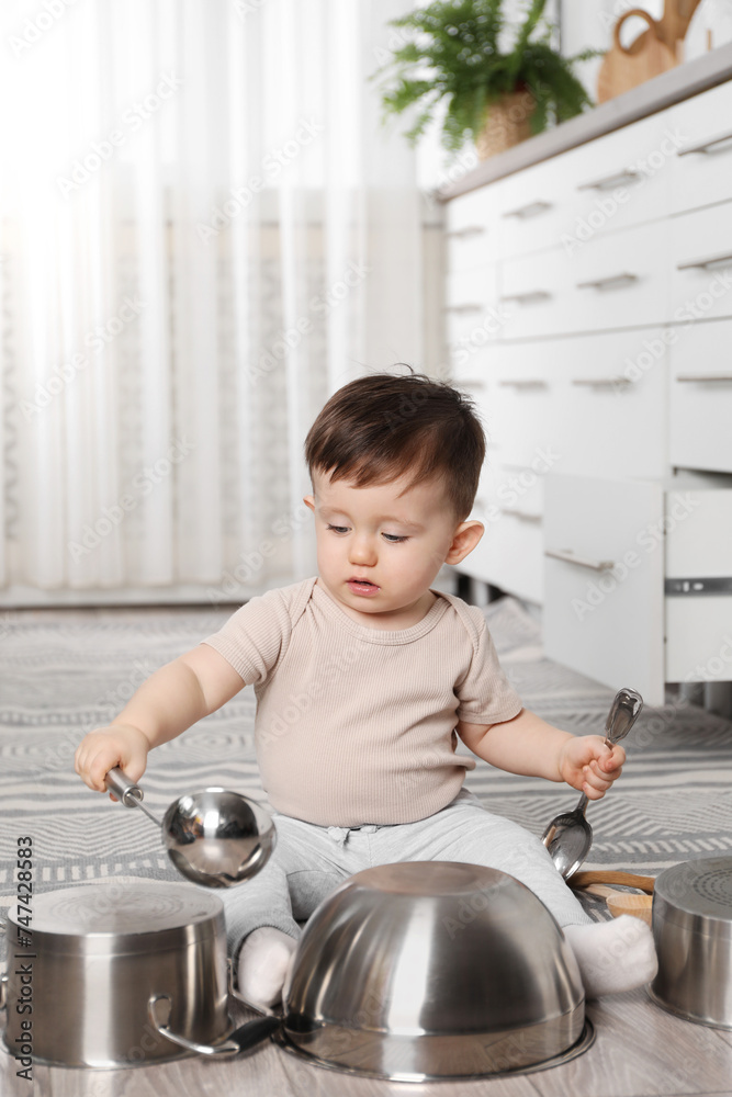 Wall mural Cute little boy with cookware at home