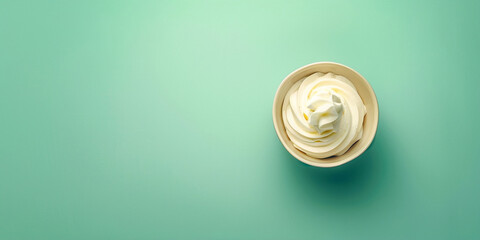 Creamy cream in a cup on a green background, top view - obrazy, fototapety, plakaty