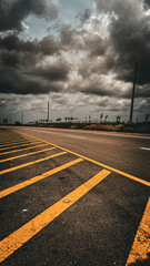 Stormy Skies Over Deserted Highway: Dramatic Cloudscape and Fading Yellow Road Markings Leading into the Horizon