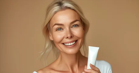 Photo sur Plexiglas Ancien avion Skin care and body lotions concept with smiling old woman holding blank tube of cream on plane beige background