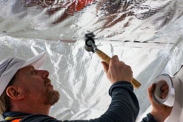 the construction worker uses aluminum tape and they had a roller for vapor barrier joints on the...