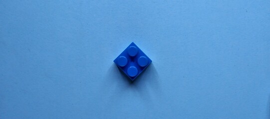 Plastic building blocks on a blue background. Minimal concept.